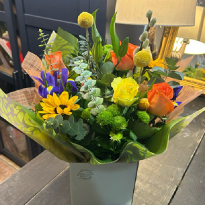 Bright and Beautiful - A vibrant, hand-tied bouquet bursting with sunflowers, craspedia, and bright roses