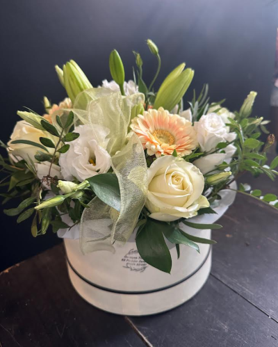 Always on my mind - A beautifully arranged hat box featuring fresh seasonal flowers in soft ivory, cream and peach tones, expertly designed for a timeless and elegant gift. Flowers are subject to seasonal availability.